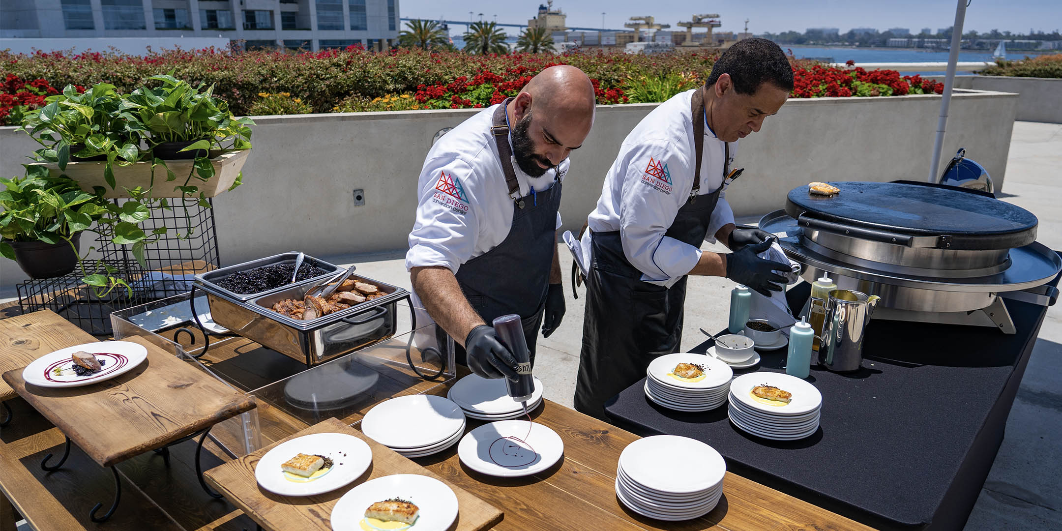 Chef Sufi Karaien preparing plates on the San Diego Convention Center's east terrace.