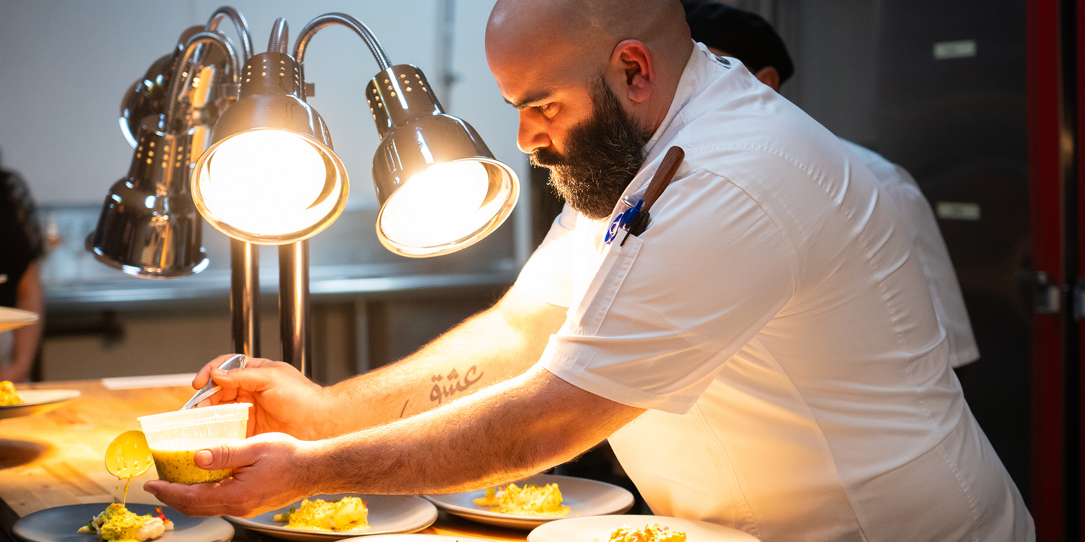Chef Sufi Karaien preparing plates on the San Diego Convention Center's east terrace.