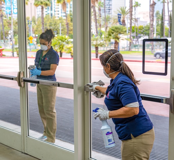 Saff cleaning pristine glass entryway doors