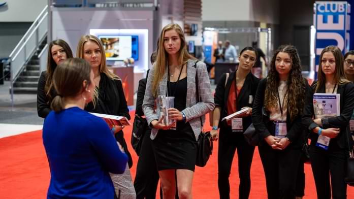 SDSU students on exhibit floor listening to a contractor speak.