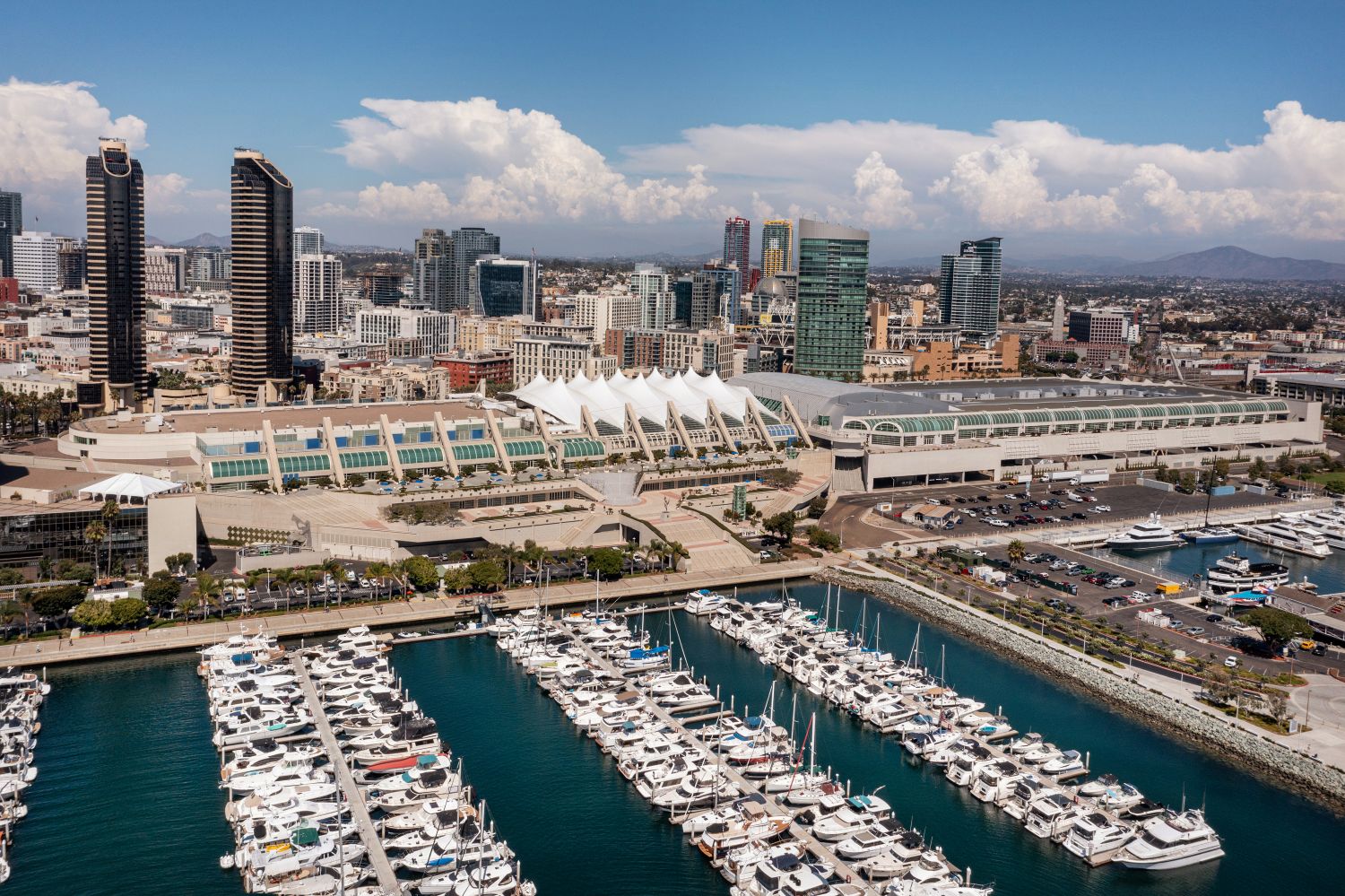 Image of the San Diego Convention Center, the downtown skyline, and the San Diego Bay with boats docked